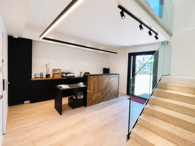 L’accueil du cabinet dentaire, bois clair et escalier de verre