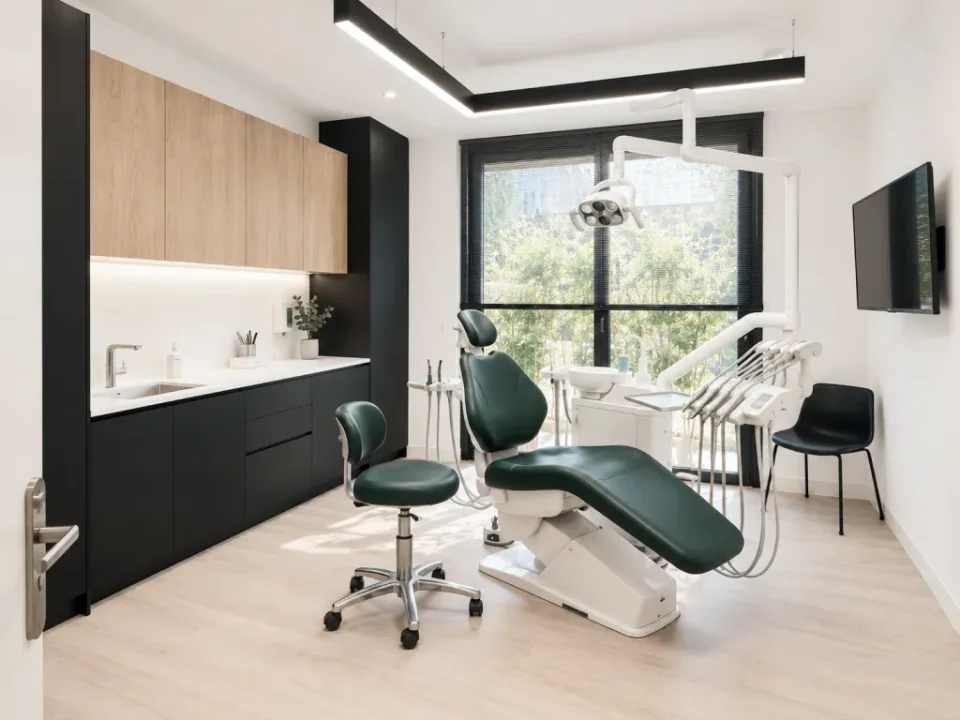 Une salle de soins du cabinet, fauteuil vert et mobilier noir